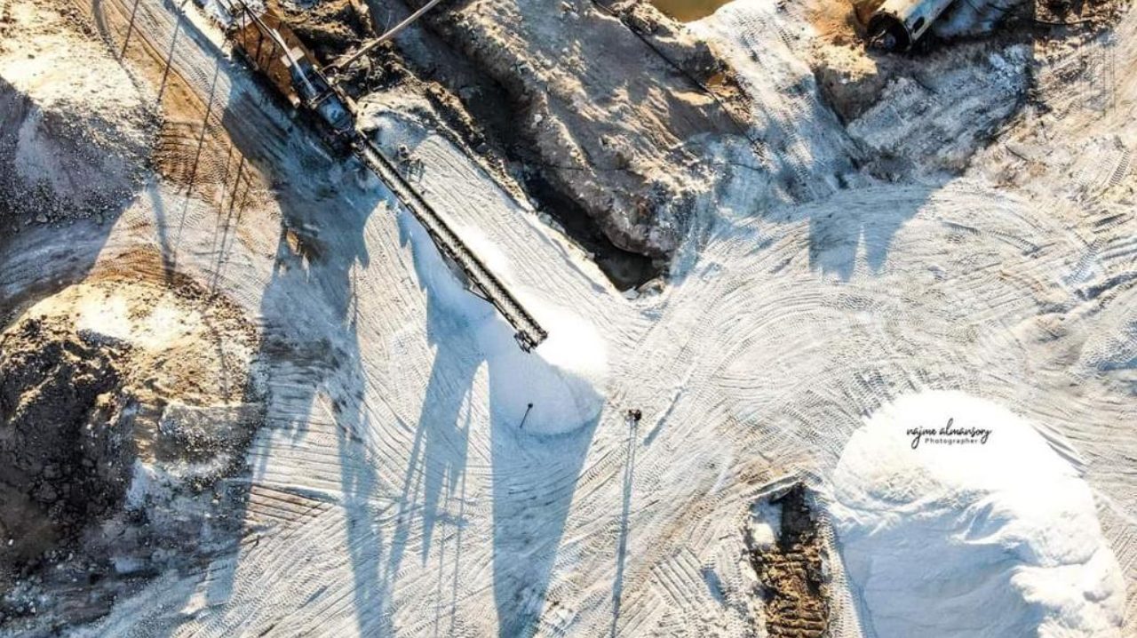 White washed sea salt stockpiles and a conveyor at the Al Mozan salt works, Libya